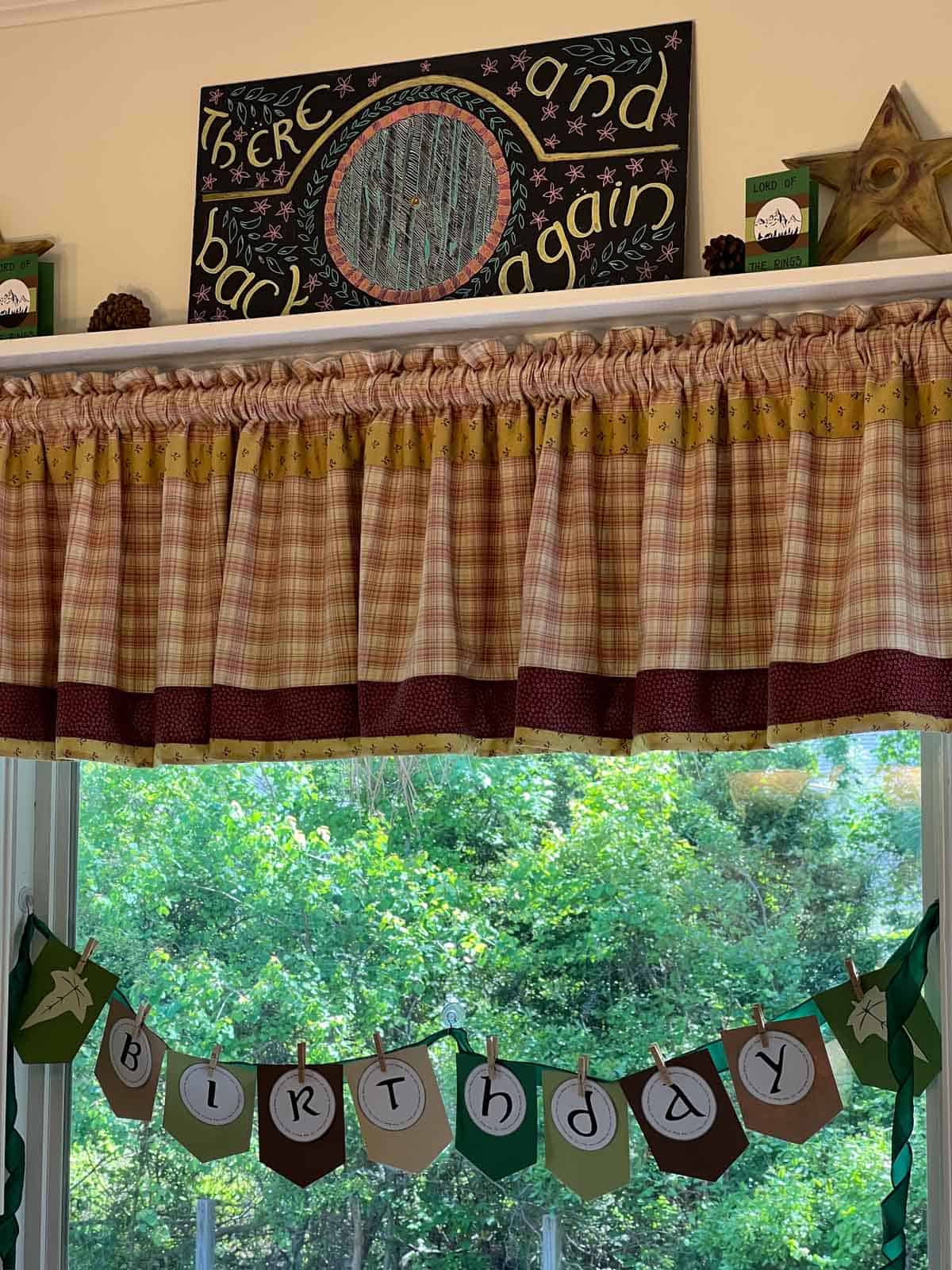 chalk sign saying "There and back again" with a hobbit hole in the center.